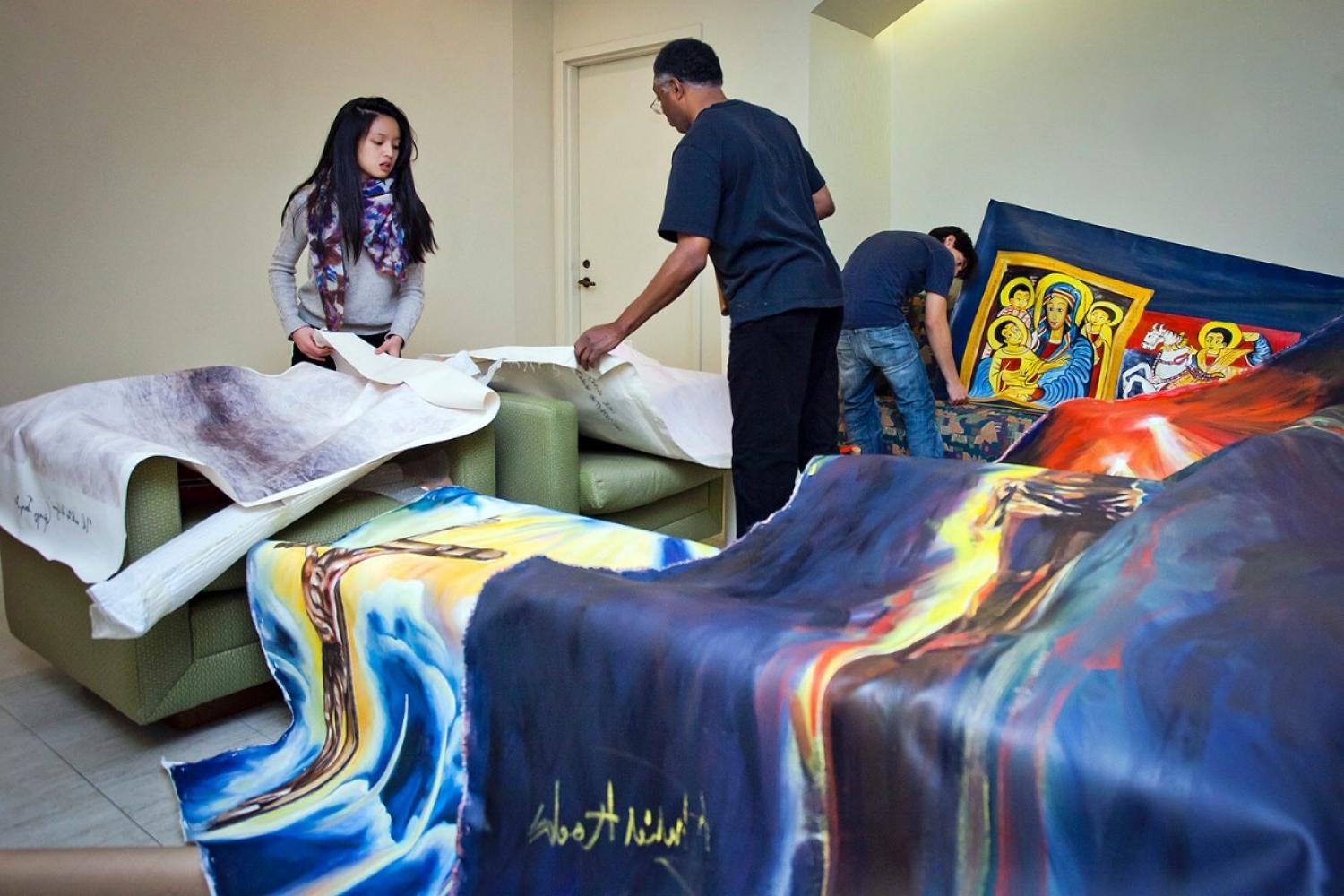 Adjunct Professor of Fine 艺术 Khalid Kodi with Art Club students, installing artwork in the Bapst Library gallery space. The artwork is related to a  project that relates to the principles and commitment to peaceful co-existence and social justice. 